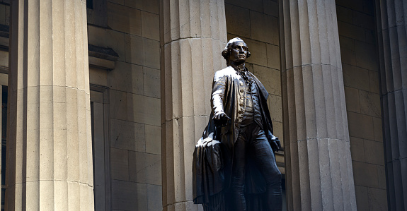 New York City, USA - February 10, 2014: George Washington Statue at Wall Street in the morning light with some snow on it. There is no people seen in the picture.