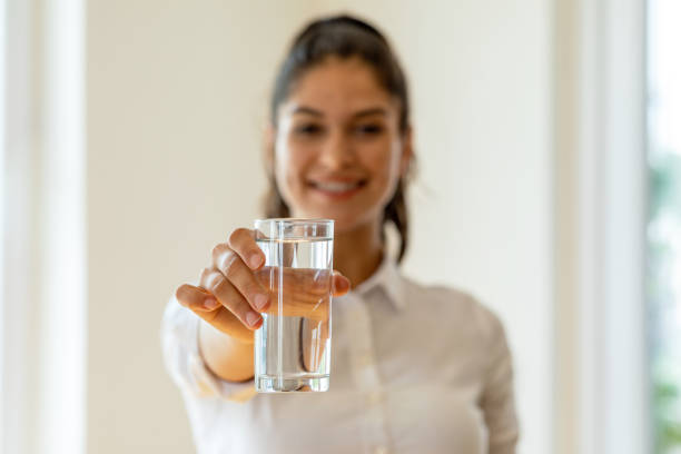水のガラスを保持している若い女の子 - water women glass healthy eating ストックフォトと画像