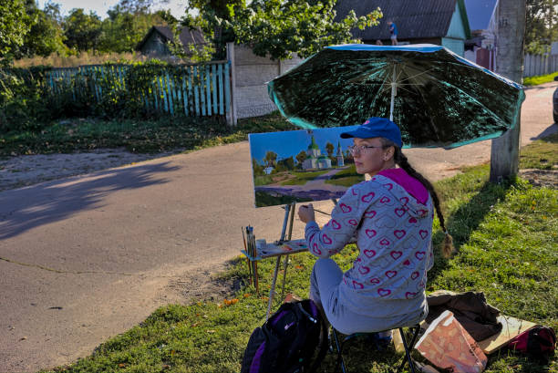 若い女性アーティストは、田舎の通りに油絵で絵を描きます。 - women artist painting easel ストックフォトと画像