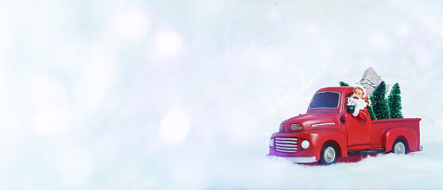 a red car Christmas decoration with Santa is on the light backgroud with bokeh. Copy space
