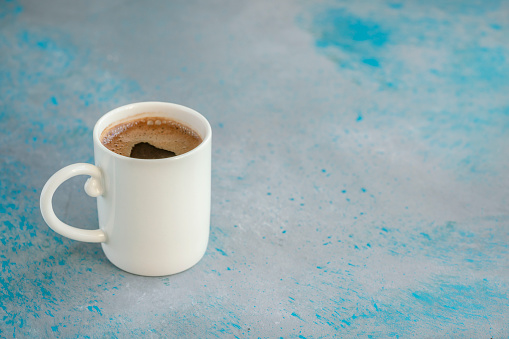 closeup cup of Turkish coffee on blue and gray background with copy space