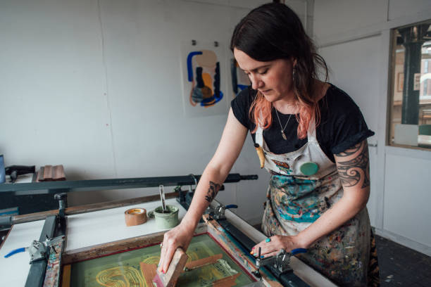 Artist and Printmaker working a printing press