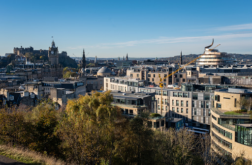 Autumn view from Calton Hill, overlooking the historic city of Edinburgh, with its old and new town landmarks. The most recent addition is the new St James Quarter shopping centre, with the new W hotel. Because of its curved and wavy shape it has been nicknamed the walnut whip. Cranes are continuing the development of new apartment blocks around the New Town retail centre.