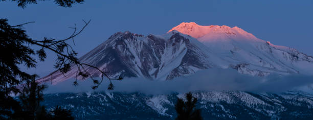 il monte shasta e gli ultimi raggi del tramonto - cascade range mountain alpenglow winter foto e immagini stock