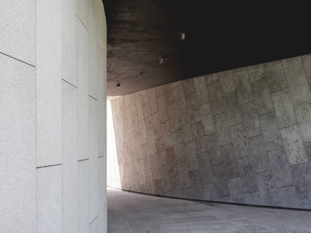 istock Modern architecture. Curving corridor in park is decorated with gray stone slabs. Diagonal laying of tiles on wall. Exterior design and landscaping. 1351556277