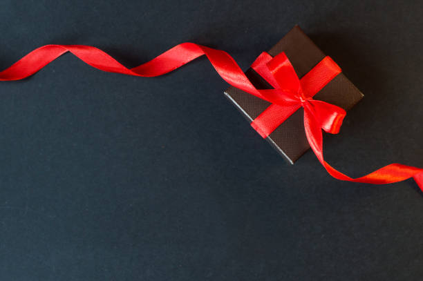 istock Black Friday - black gift box with a red bow on a dark background. 1351557201