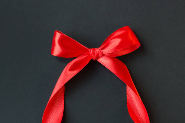 istock Black Friday - red ribbon with a bow on a dark background. 1351557230