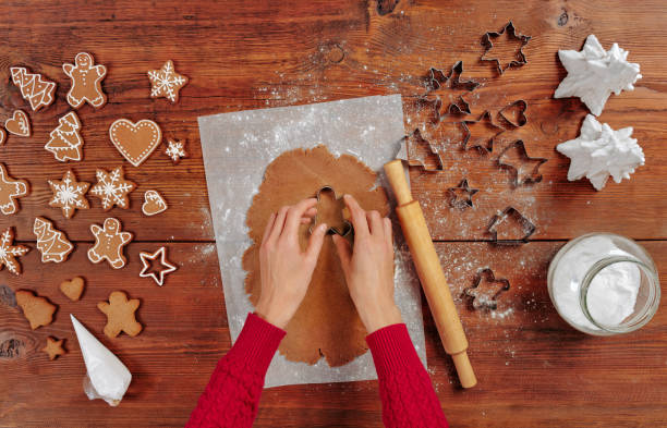 istock making Christmas gingerbread in the different form on a brown wooden background. cutting man shapes in cookie dough 1351561293