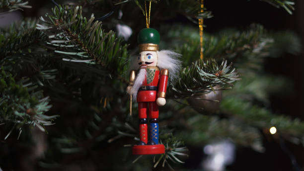 istock Decoration Toy Nutcracker on Christmas Tree. Nutcracker Soldier on a Christmas Tree With Blurred Background. Beautiful Decorated Christmas Tree, the Nutcracker Toy, Fairy Lights. Rack Focus 1351565617