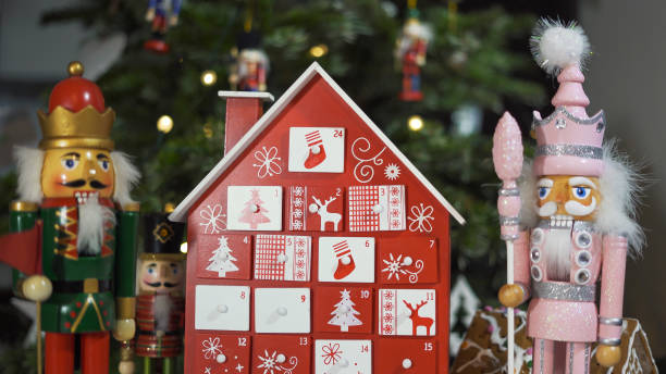 calendrier de l’avent d’arbre en bois devant un vrai sapin de noël décoré de jouets de soldat casse-noisette. lumières de fées sur un arbre de noël avec un arrière-plan flou - advent calendar advent christmas tree christmas photos et images de collection