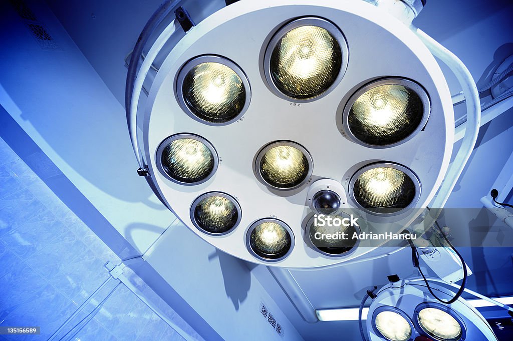 Surgical lamps in operation room hospital Two surgical lamps in operation room. Blue cast light represent purity and clinical mood. Useful file for your hospital brochure, medical article and other purpose. Lighting Equipment Stock Photo