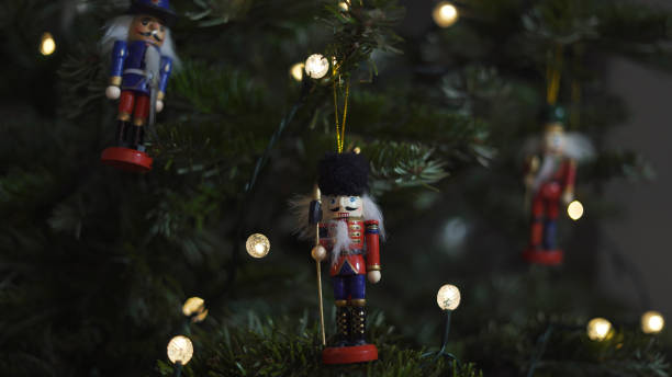 istock Decoration Toy Nutcracker on Christmas Tree. Nutcracker Soldier on a Christmas Tree With Blurred Background. Beautiful Decorated Christmas Tree, the Nutcracker Toy, Fairy Lights. Rack Focus 1351566180