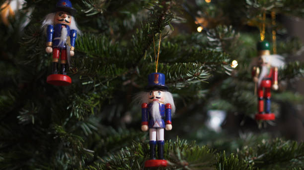 istock Decoration Toy Nutcracker on Christmas Tree. Nutcracker Soldier on a Christmas Tree With Blurred Background. Beautiful Decorated Christmas Tree, the Nutcracker Toy, Fairy Lights. Rack Focus 1351566185
