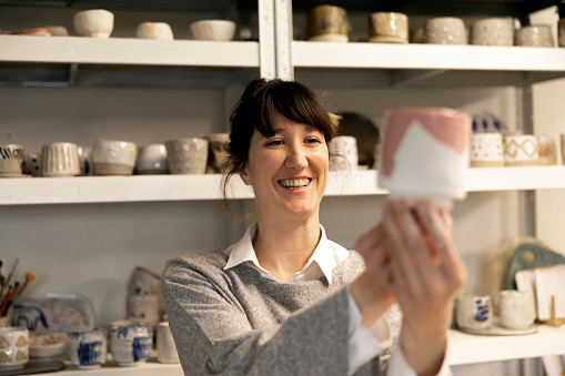 Female Artisan happy with the final result of her ceramic work