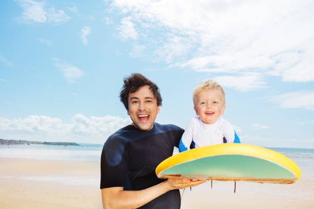 istock Fun with surfboard, father and son on the ocean 1351574112