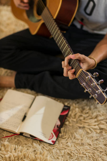 istock Man playing guitar and composing at home 1351575204