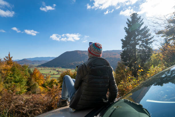 mulher sentada no carro e curtindo o sol de outono com vista para o vale de planinsko polje, eslovênia - planinsko polje - fotografias e filmes do acervo