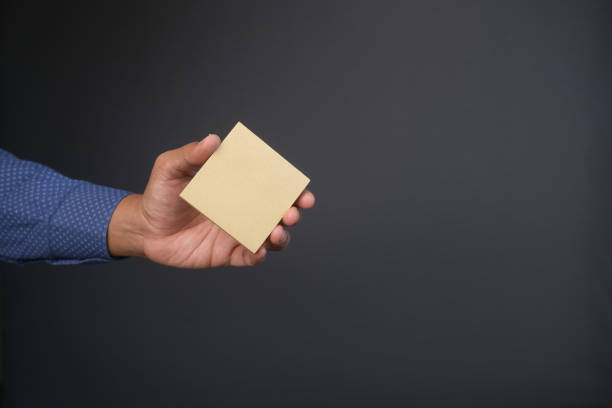 istock man hand hold a sticky note against gray background 1351592207