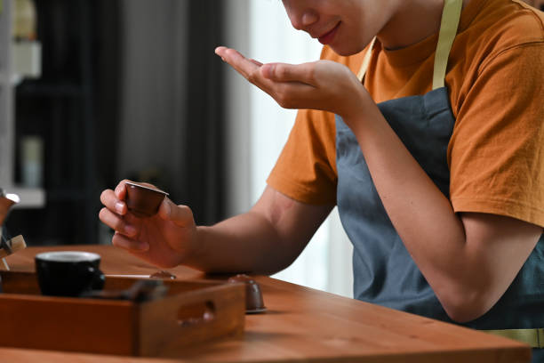 istock Young asian man smelling roasted coffee beans in his hands. 1351600104