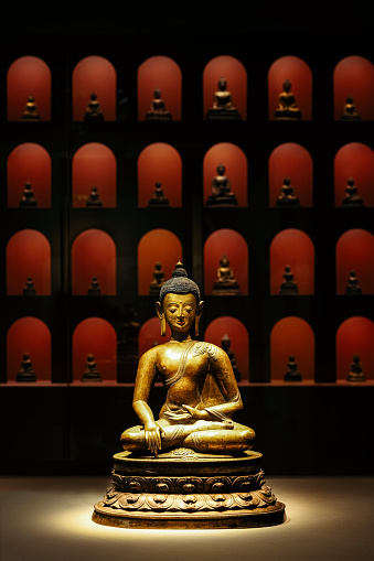 Golden sitting Guanyin and countless red little Guanyin behind him photographed in Chengdu