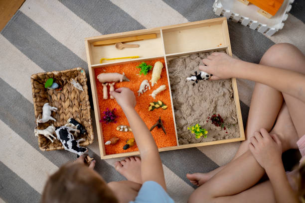 istock Touch drawer with rainbow rice inside. Children hand touch the texture. Montessori material concept for toddlers. 1351603674
