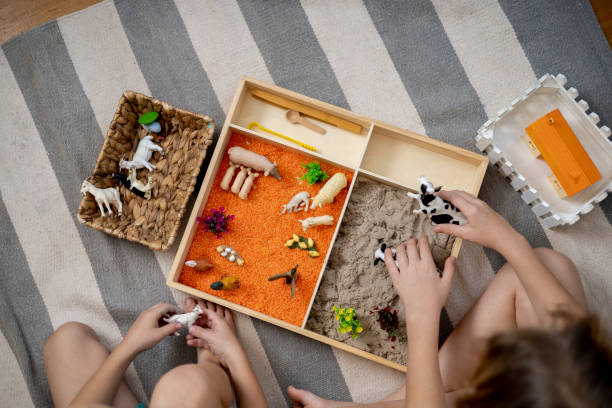 istock Touch drawer with rainbow rice inside. Children hand touch the texture. Montessori material concept for toddlers. 1351603675