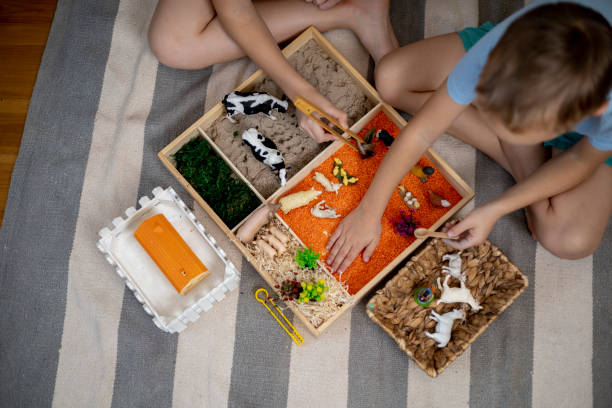 istock Touch drawer with rainbow rice inside. Children hand touch the texture. Montessori material concept for toddlers. 1351603718