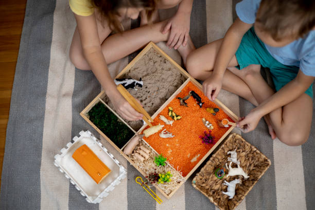 istock Touch drawer with rainbow rice inside. Children hand touch the texture. Montessori material concept for toddlers. 1351603777