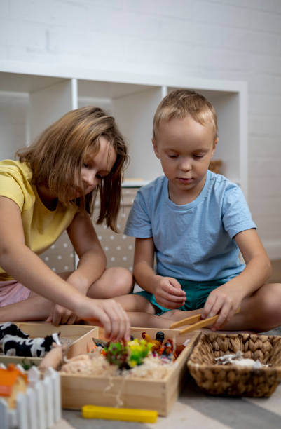istock Touch drawer with rainbow rice inside. Children hand touch the texture. Montessori material concept for toddlers. 1351606785