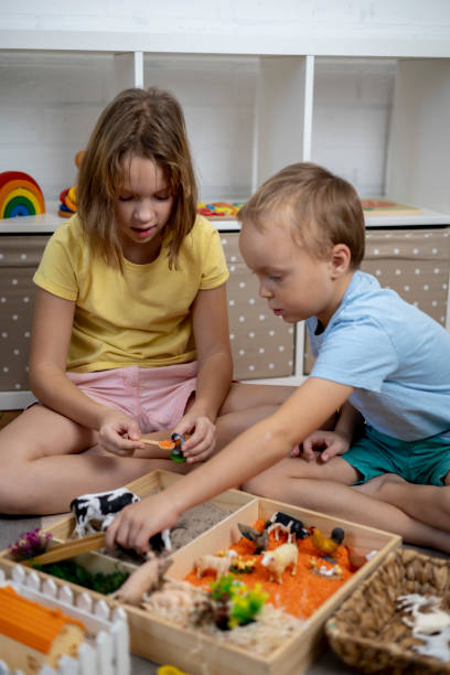 istock Touch drawer with rainbow rice inside. Children hand touch the texture. Montessori material concept for toddlers. 1351606787