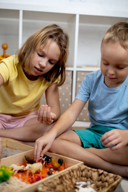 istock Touch drawer with rainbow rice inside. Children hand touch the texture. Montessori material concept for toddlers. 1351606789