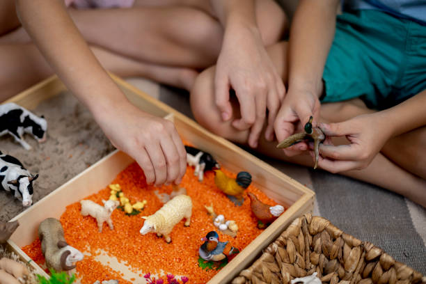 istock Touch drawer with rainbow rice inside. Children hand touch the texture. Montessori material concept for toddlers. 1351606813