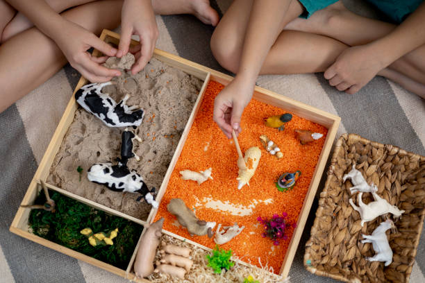 istock Touch drawer with rainbow rice inside. Children hand touch the texture. Montessori material concept for toddlers. 1351606824