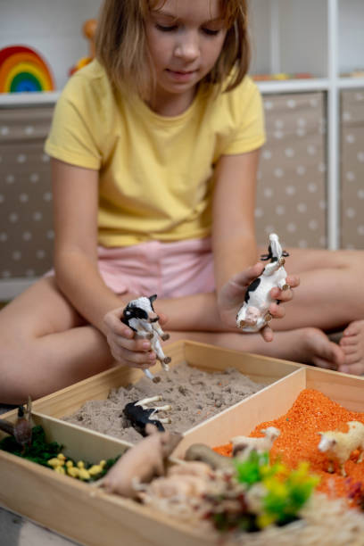 istock Touch drawer with rainbow rice inside. Children hand touch the texture. Montessori material concept for toddlers. 1351606860