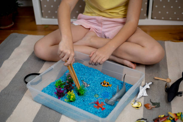 istock Touch drawer with rainbow rice inside. Children touch the texture. Montessori material concept for toddlers. 1351607457
