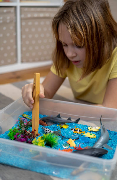 istock Touch drawer with rainbow rice inside. Children touch the texture. Montessori material concept for toddlers. 1351607545