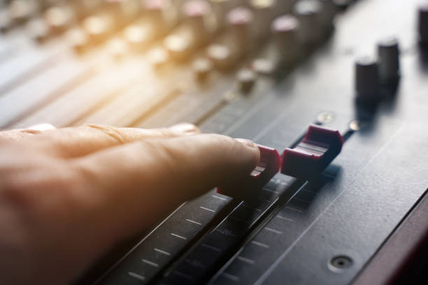 The person controls the regulator on the music console. Entertainment industry. The person controls the regulator on the music console. sound technician stock pictures, royalty-free photos & images