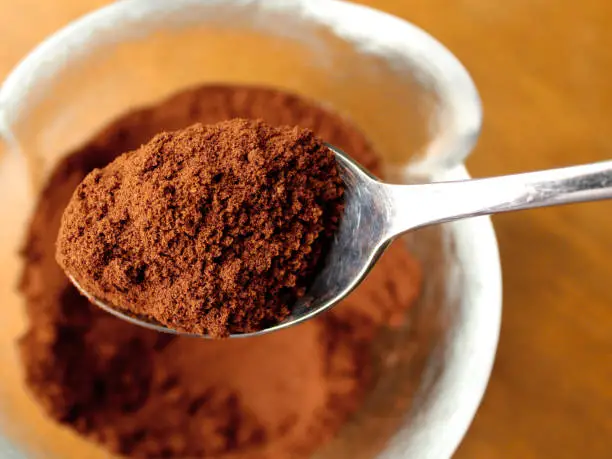 Photo of Ground coffee in the spoon, top view