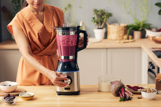 istock Young housewife with electric blender preparing smoothie 1351622003