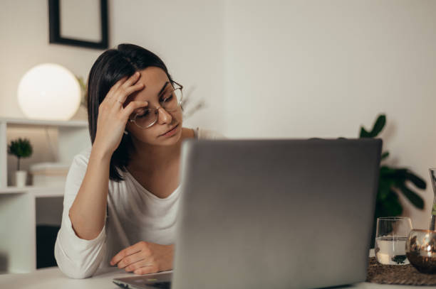 istock Woman feeling tired and stressed while using a laptop and working from home 1351623253