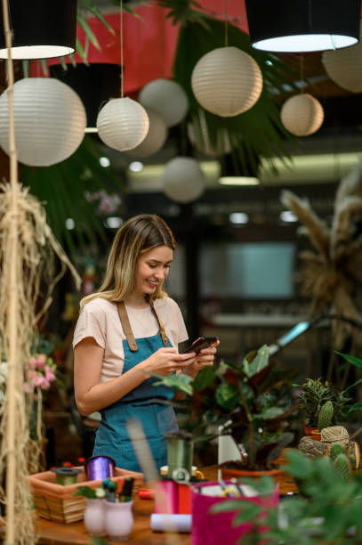 istock Florist using smartphone in a flower shop 1351623862