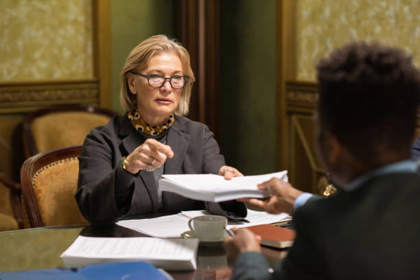 istock Mature businesswoman passing stack of signed documents to colleague 1351626205
