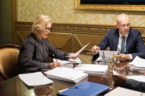 istock Bald man talking to colleague while female lawyer making notes 1351626214