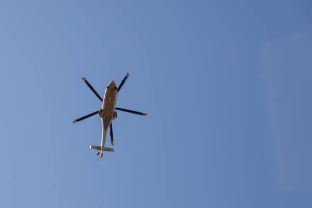 istock Helicopter flying in the blue sky bottom view. 1351626553