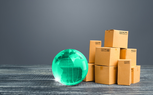 Light green globe and cardboard boxes. Economic relations commerce. Freight transportation. Distribution and trade exchange goods around the world, retail and sales. Global business, import, export.