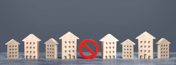 czerwony znak zakazu nie stoi wśród budynków mieszkalnych. ograniczenia zakazują budowy. niedostępne drogie mieszkania. ograniczenie zagęszczania budynku. słabo rozwinięta infrastruktura użyteczności publicznej - underdeveloped zdjęcia i obrazy z banku zdjęć
