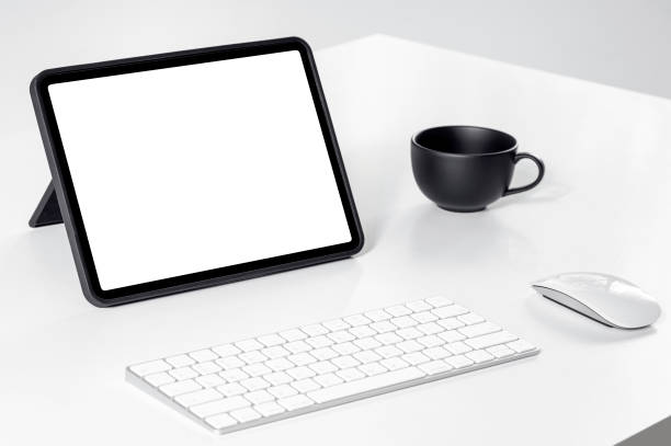 istock Mockup blank white screen portable tablet with keyboard and mouse on white table. 1351632963