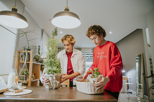 Thai nonbinary people after buying some trees and food at the refill shop, just arrive house for the celebration of Christmas events and the long holiday.