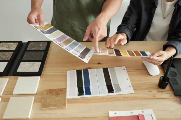 istock Hands of two young designers discussing textile samples 1351641336