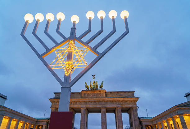 brandenburger tor hinter beleuchteter menora am brandenburger tor in berlin - hanukkah menorah judaism religion stock-fotos und bilder